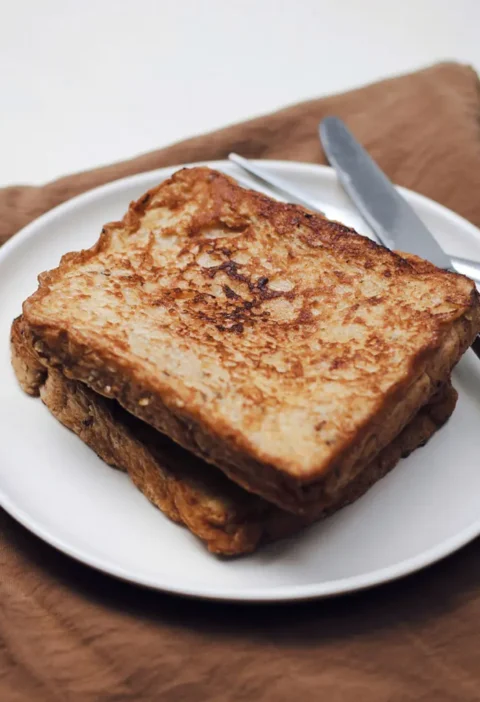 Une assiette contenant deux tranches de pain grillé, illustrant la recette du pain perdu traditionnel.