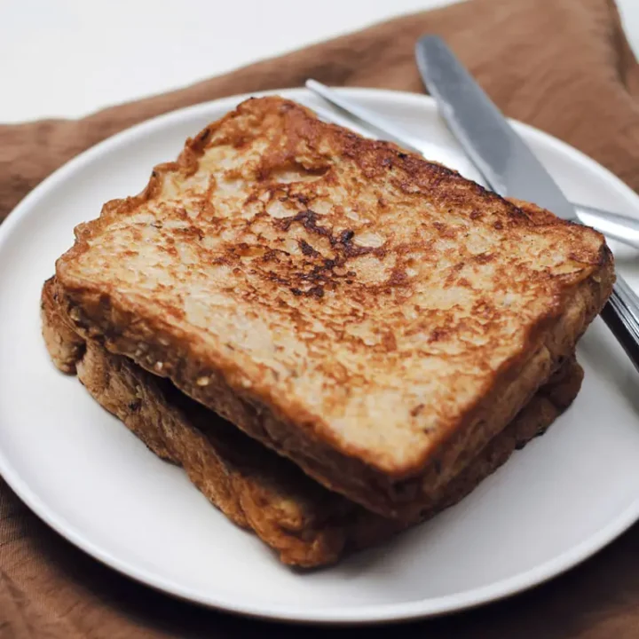 Une assiette contenant deux tranches de pain grillé, illustrant la recette du pain perdu traditionnel.
