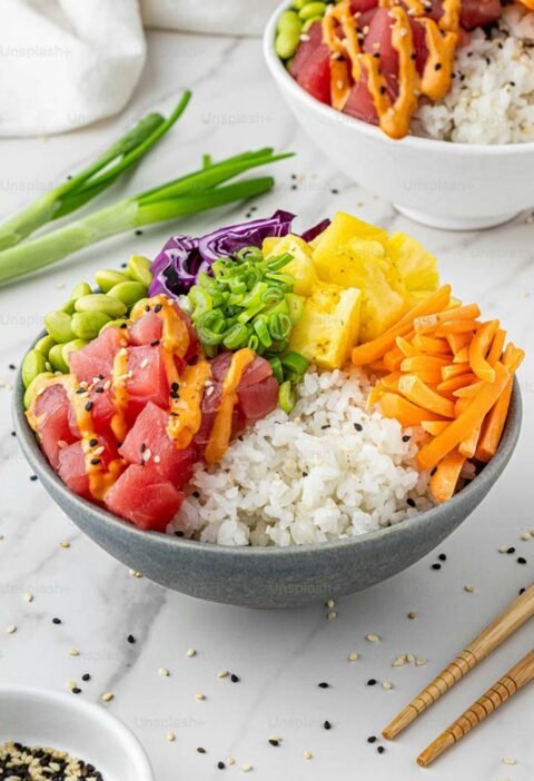 Un bol de sushi coloré avec des légumes frais et du riz, représentant une recette facile de Poke Bowl au thon ahi