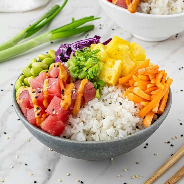 Un bol de sushi coloré avec des légumes frais et du riz, représentant une recette facile de Poke Bowl au thon ahi