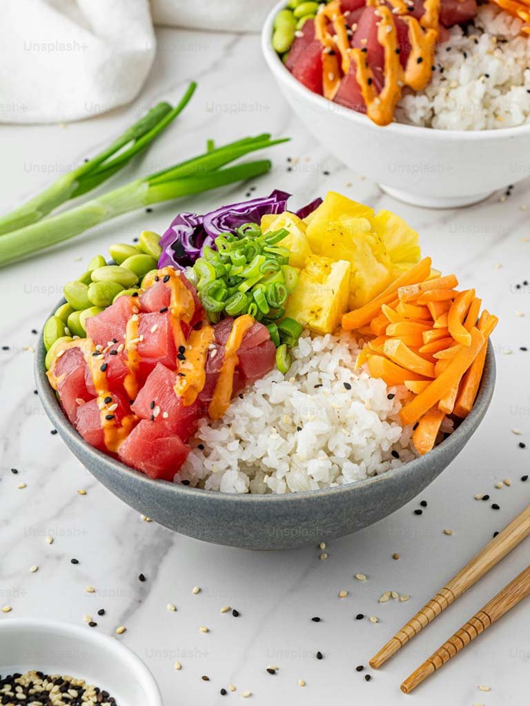 Un bol de sushi coloré avec des légumes frais et du riz, représentant une recette facile de Poke Bowl au thon ahi