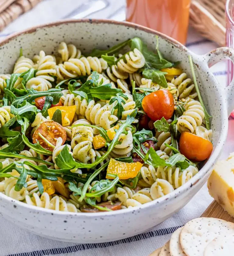 Un bol de salade de pâtes avec des tomates, du fromage et du pain, intitulé - Salade de Pâtes Facile et Savoureuse