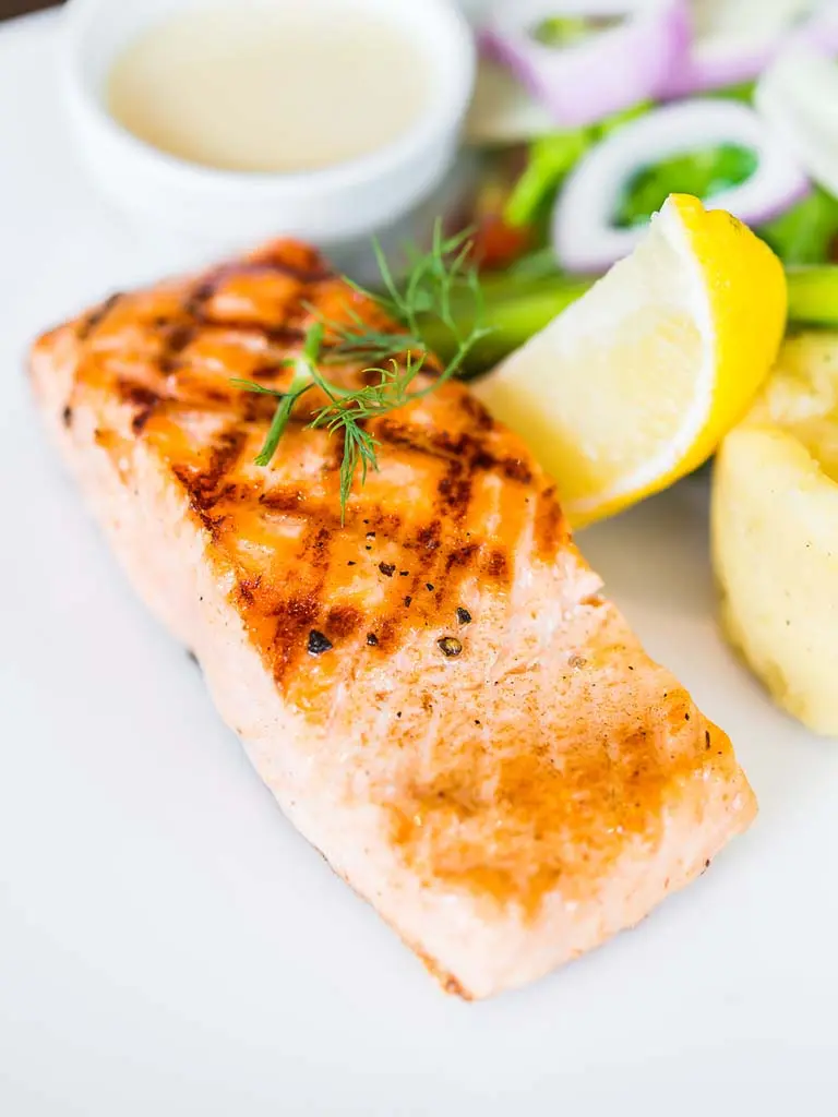 Plat de saumon grillé, pommes de terre rôties et haricots verts, illustrant une recette facile de saumon au four.